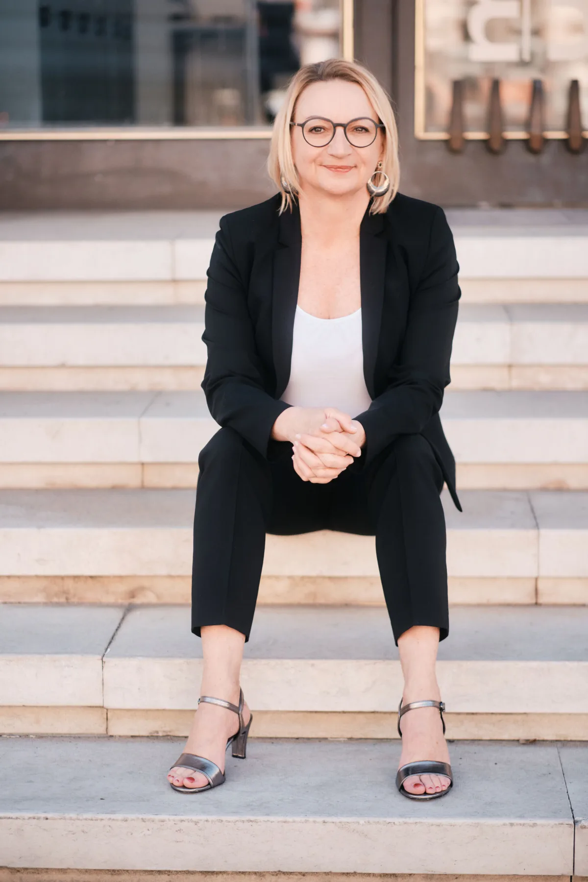 Gerlinde Oberndorfer — sitzend auf Stufen, im Gespräch bereit